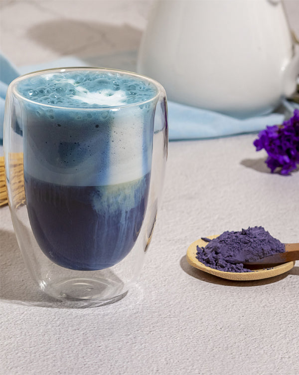 Blue Matcha dans un verre de latte posé sur une table
